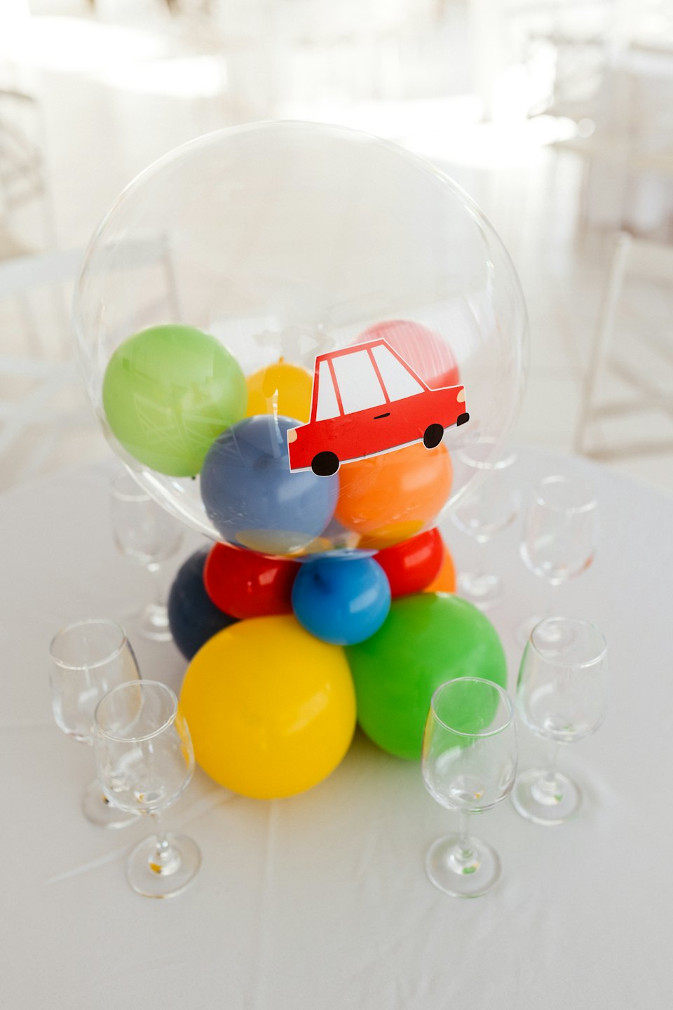 A balloon filled with colorful mini balloons sits on a table.